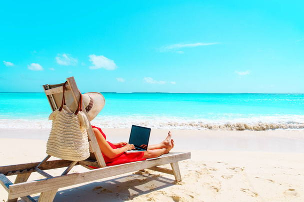 lavoro a distanza concetto-giovane donna con computer portatile sulla spiaggia
 - Foto, immagini