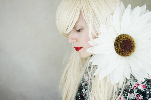大きな白いデイジーの花とかわいいドレスの若いブロンドの女性の写真 - 写真・画像