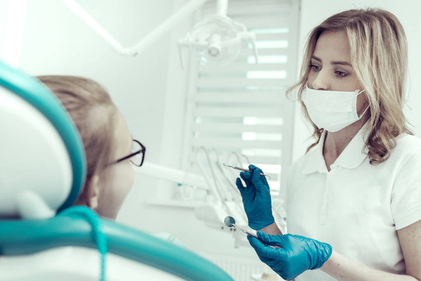 Young beautiful dentist holding necessary dental tools - Foto, immagini
