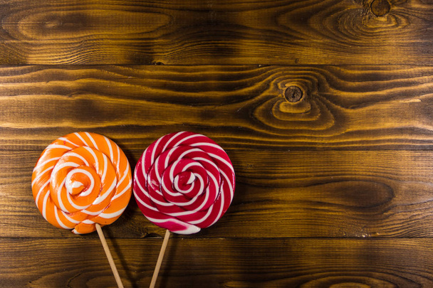 Sweet lollipops on rustic wooden background. Top view - Fotoğraf, Görsel