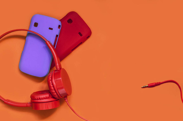 stylish headphones and cases for your phone on an orange background - Φωτογραφία, εικόνα
