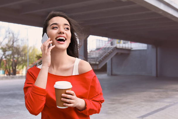 Young woman talking on mobile phone outdoors - Photo, image