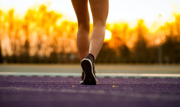 Legs of athlete woman running on racetrack on stadium track - Foto, imagen