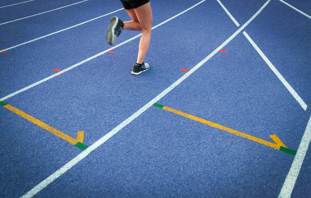 Legs of athlete woman running on racetrack at stadium - Fotoğraf, Görsel