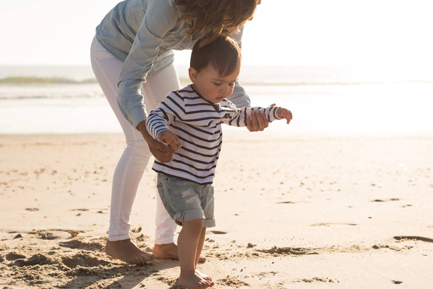 Jonge moeder verkennen van het strand met haar baby - Foto, afbeelding