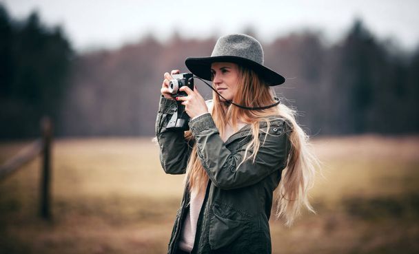 Young woman with vintage camera walking on rural area - Fotografie, Obrázek