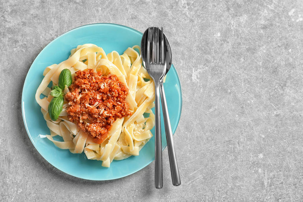 Plate with delicious pasta bolognese on light background, top view - Foto, afbeelding