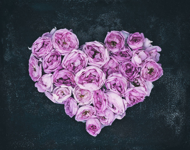 Herz aus Knospen und Blütenblättern rosa Rosen - Symbol der Liebe. - Foto, Bild