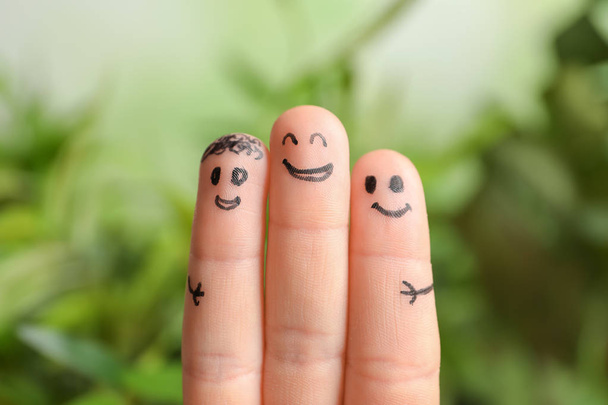 Fingers with drawings of happy faces against blurred background. Unity concept - Fotoğraf, Görsel