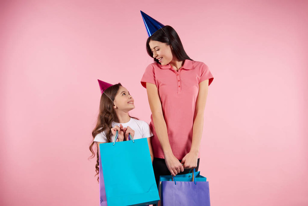 Young mother and daughter in party caps - Foto, imagen