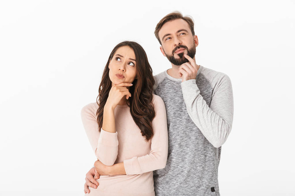 Image of serious thinking young loving couple isolated over white wall background looking aside. - Foto, Imagen