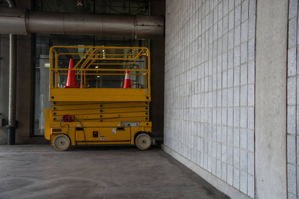 salão de armazém de distribuição com plataforma de elevação de tesoura hidráulica
 - Foto, Imagem