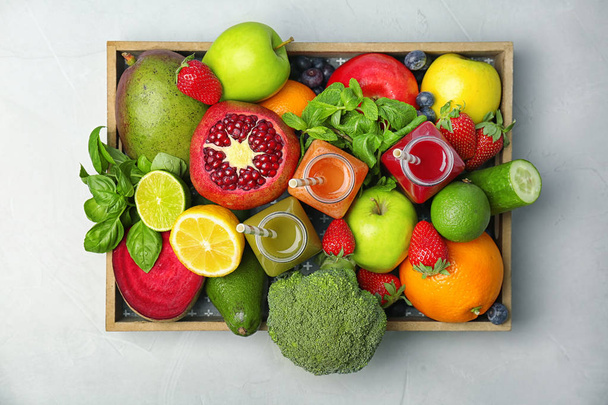Crate with healthy detox smoothies and ingredients on light background, top view - Foto, immagini
