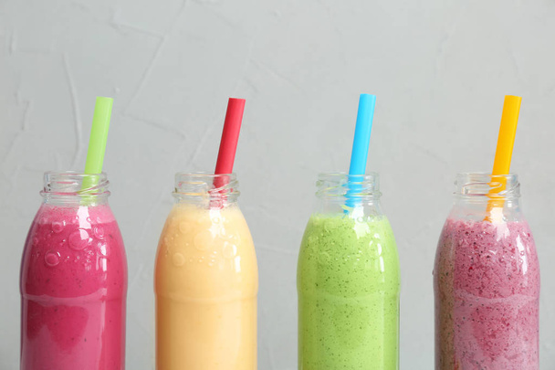 Bottles with healthy detox smoothies on grey background - Photo, image
