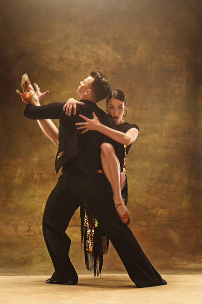 Dance ballroom couple in gold dress dancing on studio background. - Fotó, kép