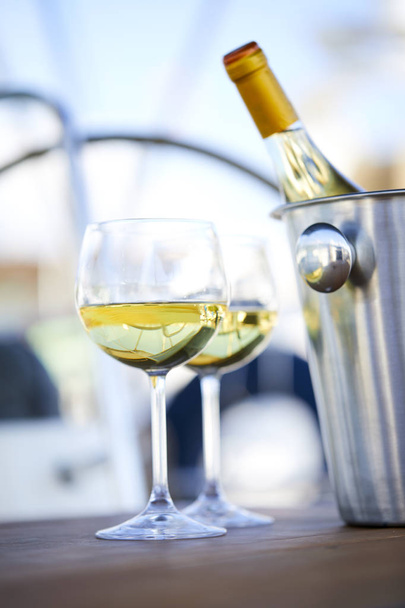 Paar wijnglazen en emmer met champagne fles op jacht - Foto, afbeelding