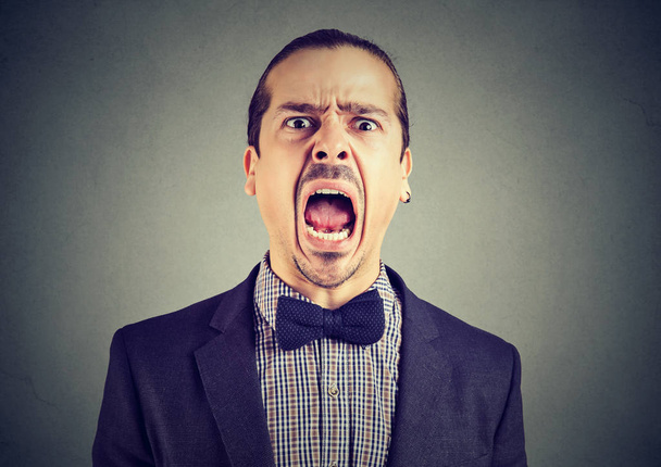 πορτρέτο ενός νεαρού άνδρα θυμωμένος ουρλιάζοντας  - Φωτογραφία, εικόνα