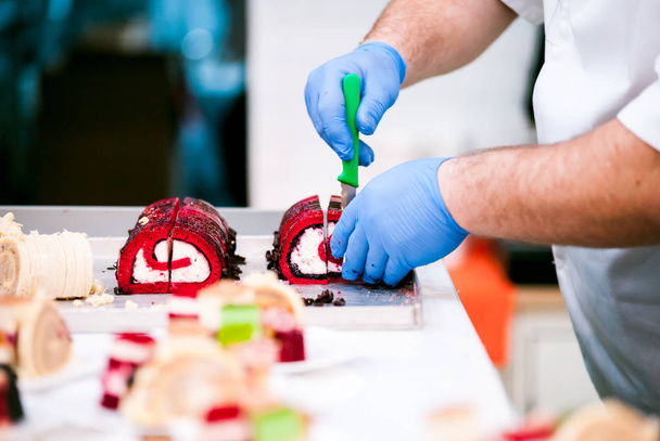 Professional confectioner cutting cakes in pastry shop  - Foto, Bild