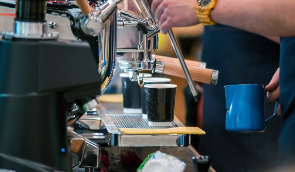 Barista preparing coffee using modern machine at coffee shop - Foto, Bild