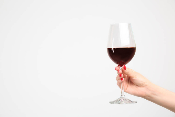 Woman holding glass of red wine on white background - Фото, изображение