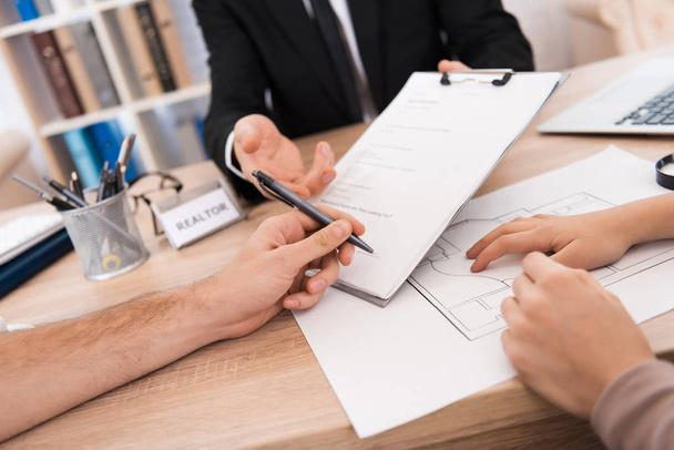 close up of man signing agreement, family buying new apartment in real estate agency - Foto, Imagem