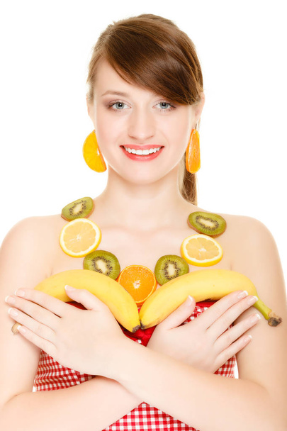 Diet. Girl with necklace and earrings of fresh citrus fruits holding bananas isolated. Woman recommending healthy nutrition - Foto, immagini