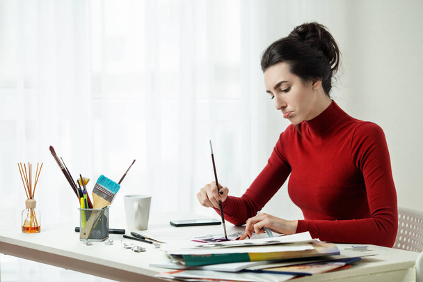 La chica dibuja sobre lienzo en una oficina brillante. Modelo de artista. rímel cepillo
. - Foto, imagen