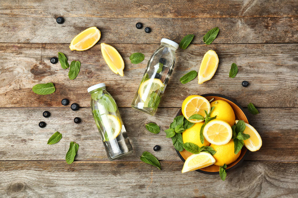 Flat lay composition with detox lemonade and ingredients on wooden background - Fotografie, Obrázek