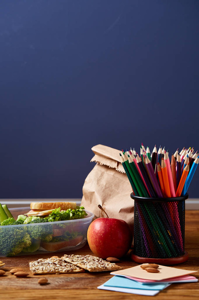 Back to School concept, school supplies, biscuits and lunchbox on wooden desk, selective focus, close-up. - Foto, imagen