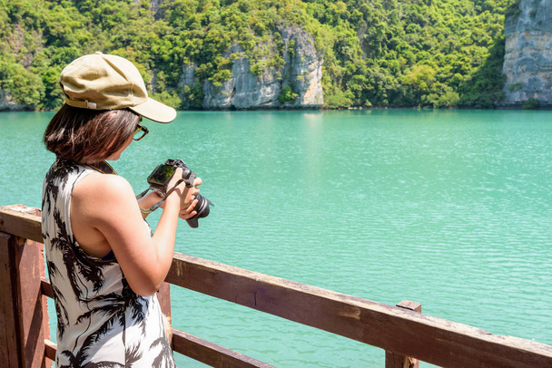 Kadın turist Thale Nai Blue Lagoon (Emerald Gölü) Mu Ko Ang Thong Milli Parkı, Surat Thani, Tayland fotoğrafları aldıktan sonra kamera bakarak Koh Mae Ko Island bakış açısı üzerinde - Fotoğraf, Görsel