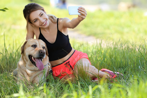 Young woman taking selfie with her dog outdoors. Pet care - Foto, Imagen