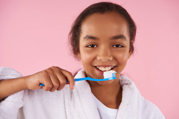 Happy African American teen girl brushes teeth. - Foto, immagini
