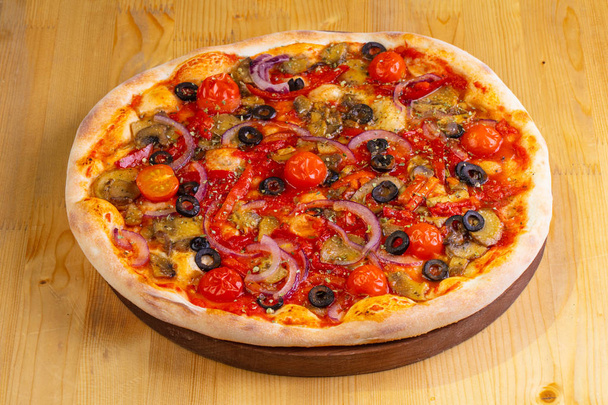 Pizza with mushrooms and tomatoes on wooden board - Photo, Image