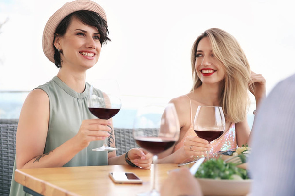 Group of friends with glasses of wine at table - Photo, image