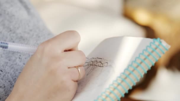 Artysta dziewczyna w okulary rysuje szkiców w notesie - Materiał filmowy, wideo