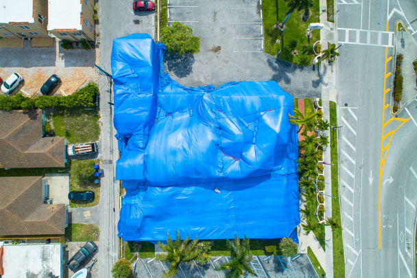 Imagen aérea de un edificio con tienda de fumigación azul
 - Foto, Imagen