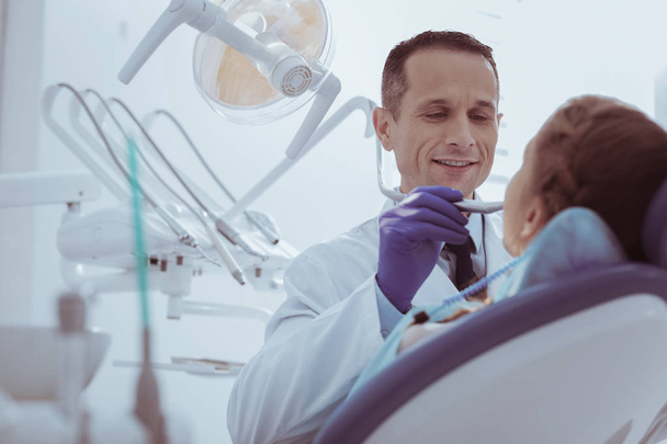 Skillful male dentist viewing oral cavity - Zdjęcie, obraz