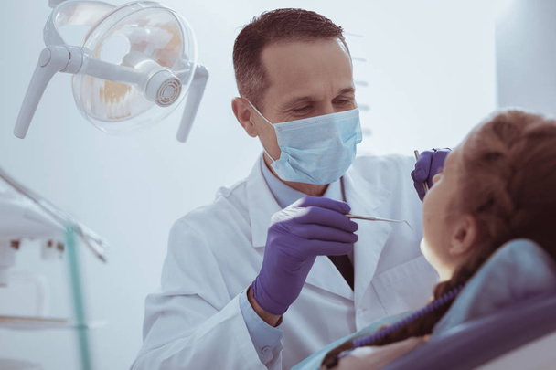 Ambitious male dentist examining gums - Fotoğraf, Görsel