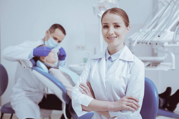 Beautiful female assistant helping dentist - Photo, image