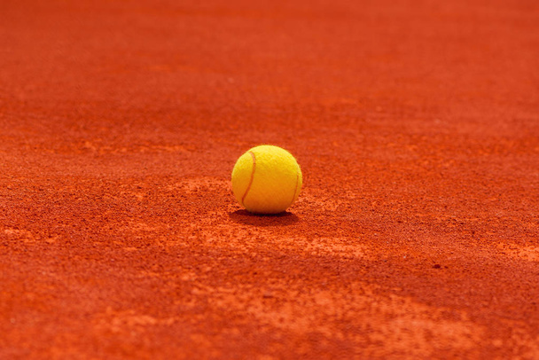 Tennis ball on clay court, selective focus with blank copy space - Zdjęcie, obraz