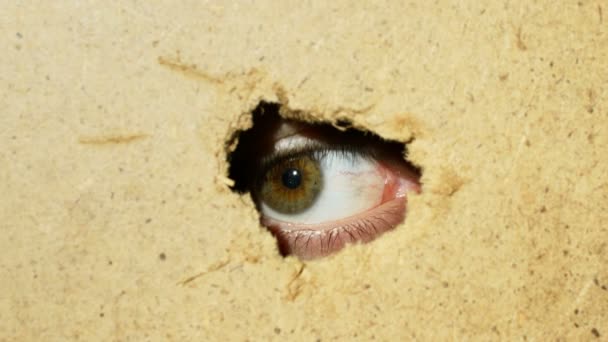 Male eye looking through hole in wall - Footage, Video
