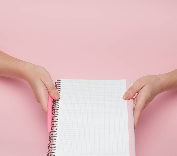Notebook and pen in hand on pink background with copy space.Business Concept and Instagram. - Photo, image