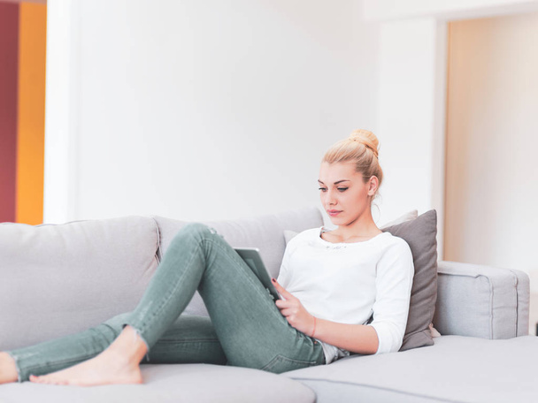 young happy woman on sofa using tablet computer at luxury home - Foto, Imagen