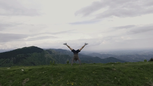 Ο άνθρωπος που κάνει ένα handstand σε εξωτερικούς χώρους σε ένα βράχο - Πλάνα, βίντεο