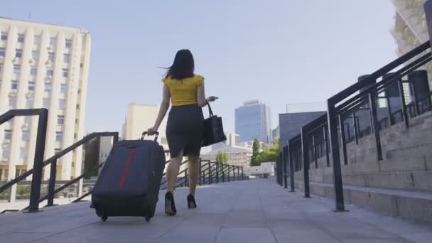 Χαμηλή γωνία της γυναίκας επιχειρήσεων με αποσκευές περπάτημα - Πλάνα, βίντεο