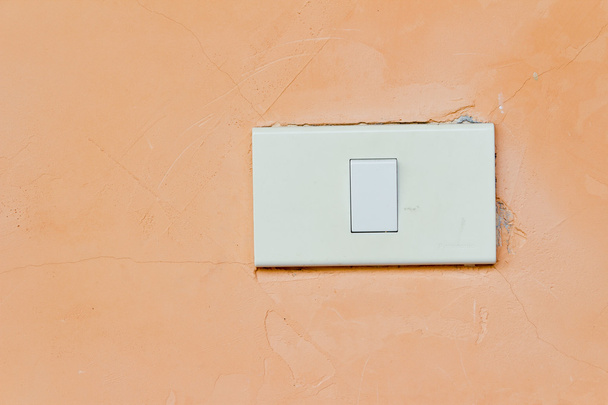 Interrupteur électrique à bascule blanc sur mur orange pastel
 - Photo, image