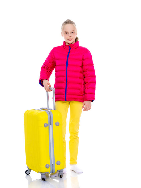 The girl gymnast with a large suitcase goes to the competition. - Foto, Bild