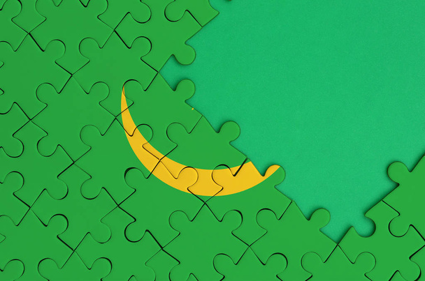 Drapeau de la Mauritanie est représenté sur un puzzle complété avec espace libre de copie verte sur le côté droit
. - Photo, image