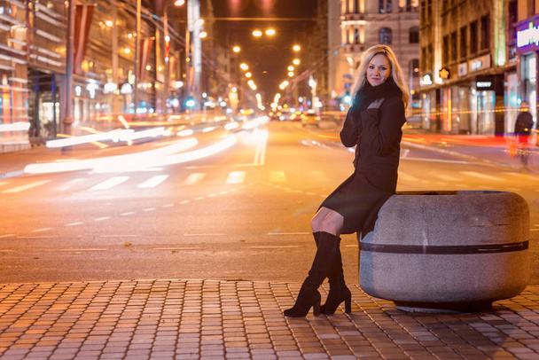 Beautiful, blonde woman in car lights in the night city. - Фото, зображення