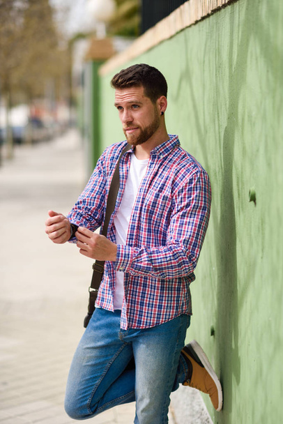 Attractive young man standing in urban background. Guy wearing casual clothes. Lifestyle concept. - Fotoğraf, Görsel